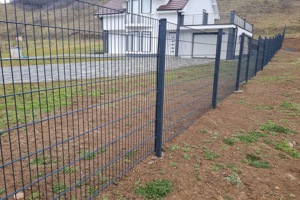 Gardh antracit 2D përgjatë një livadhi para një shtëpie të bardhë